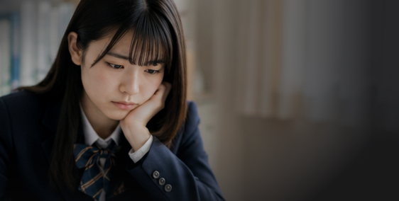 図書室で頬杖をついて悩む制服姿の女子生徒