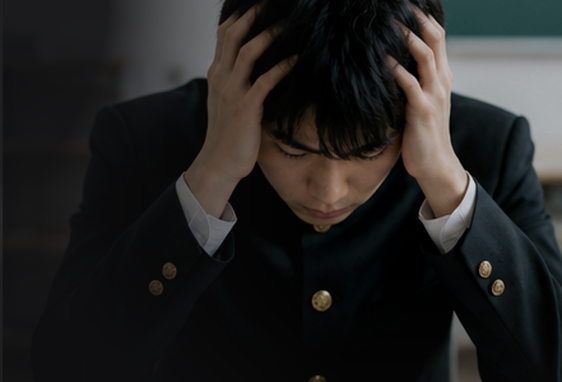 教室で頭を抱えて悩む学ラン姿の男子生徒